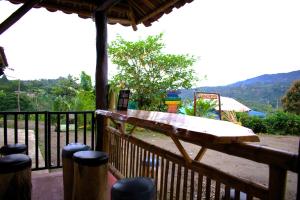 a wooden deck with a table on a fence at Sanagua Cascadas del Lavapatas in San Agustín