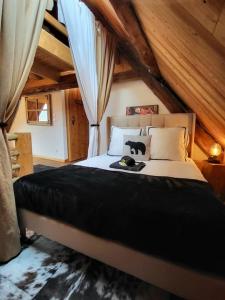 a bedroom with a large bed with a cat on it at Le Cosy Lodge Départs Vélo Ski Alpe d'Huez 2 Alpes La Grave Détente Jacuzzi Piscine Sauna Bar Billard in Le Bourg-dʼOisans +45 photos