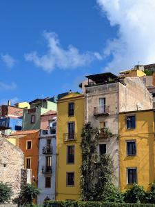 ein hohes gelbes Gebäude vor einer Stadt in der Unterkunft Antica Dimora - Appartamento 2 in Bosa