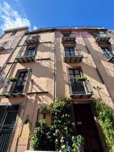ein hohes Gebäude mit Balkonen und Pflanzen darauf in der Unterkunft Antica Dimora - Appartamento 2 in Bosa + 2 Fotos