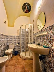 ein Bad mit einer Dusche, 2 Waschbecken und einem WC in der Unterkunft Antica Dimora - Appartamento 2 in Bosa