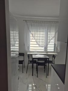 a dining room with a table and chairs and a window at Nati in Radom +3 photos