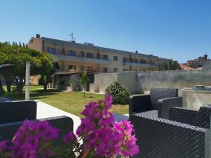 a view of a building with chairs and purple flowers at Casa la Grenadine in Esmoriz