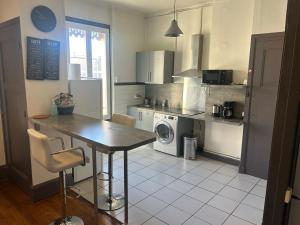 - une cuisine avec une table et un lave-linge/sèche-linge dans l'établissement Spacieux cosy - 1 chambre Appartement - LYON Perrache Confluence 50 M2, à Lyon