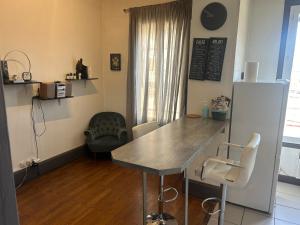 une cuisine avec une table et des chaises dans une pièce dans l'établissement Spacieux cosy - 1 chambre Appartement - LYON Perrache Confluence 50 M2, à Lyon