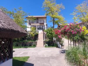 a house with pink flowers and a pathway at Casa de Vacanta Simfonia Apelor in Dunavăţu de Jos
