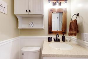 ein Badezimmer mit Waschbecken, Toilette und Spiegel in der Unterkunft Little Lake Cottage in Lake Lure