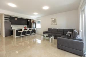 a living room with a couch and a kitchen at Sea&Sand Apartment - Modern Sea View near Sandy Beaches in Privlaka