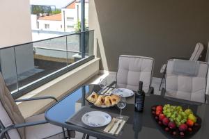 a table with a tray of food and a plate of fruit at Sea&Sand Apartment - Modern Sea View near Sandy Beaches in Privlaka
