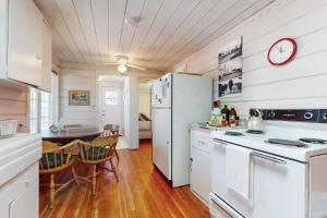 a kitchen with a white refrigerator and a table at Walk to Town! Dog-Friendly Quincy Getaway w/ Deck in Quincy