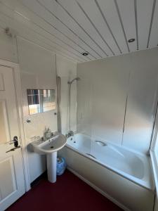 a white bathroom with a sink and a tub and a sink at Marston town centre villa in Blackpool +19 photos