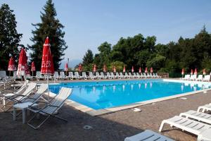 a large swimming pool with chairs and umbrellas at Selva Coccinella in Cissano