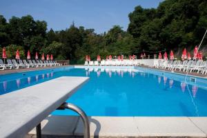 a large swimming pool with chairs and umbrellas at Selva Coccinella in Cissano