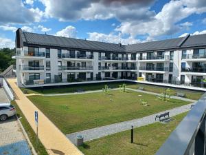 an apartment building with a park in front of it at Jantar Up in Jantar