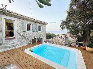 a swimming pool in front of a house at Villa Tilda in Argyrátika