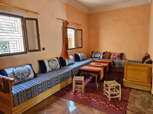 a living room with a couch and a table at Merzouga Quiet apart &camels trecking in Merzouga