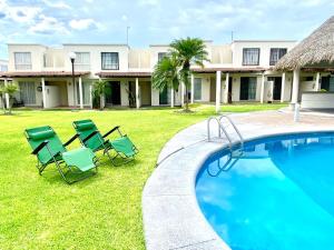 a group of lawn chairs next to a swimming pool at LA CASABONITA vistalberca AirA in Alpuyeca