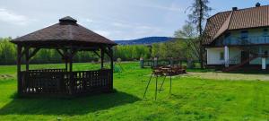 a gazebo with a table and benches in a yard at U Gienka Pod Lasem in Święta Katarzyna