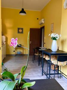 a room with two tables and a vase with flowers on it at B&B Metropolitan RC in Reggio di Calabria