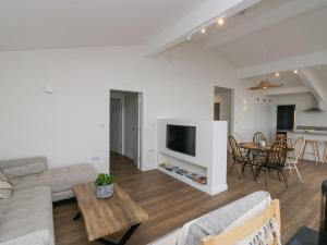 a living room with a couch and a tv and a table at Driftwood Cottage in Ulverston
