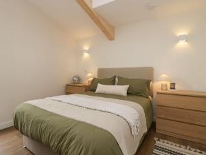 a bedroom with a large bed and two night stands at Driftwood Cottage in Ulverston