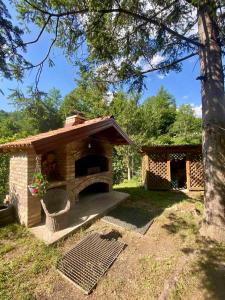 a small brick oven in a yard with a tree at Vila Dolina Izvora in Sarajevo
