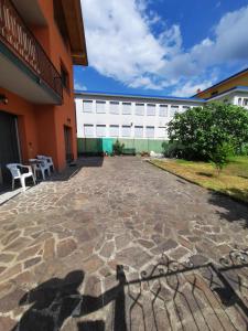 a building with a stone patio in front of a building at La Rosa di Emma in Porlezza