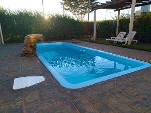 a swimming pool with a water fountain in a yard at Vila Caluca Olimpia - Flats & Suites in Olímpia