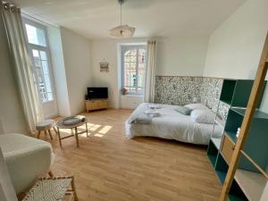 a bedroom with a bed and a living room at T1 bis à la décoration soignée in Lamballe Armor