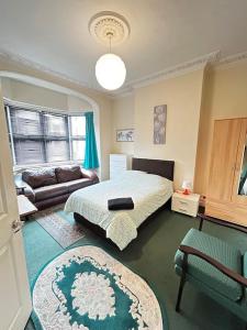 a bedroom with a bed and a couch at Amazing 6 bedroom house with free parking on site. in Norbury