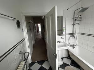 a bathroom with a sink and a mirror at Amazing 6 bedroom house with free parking on site. in Norbury +20 photos