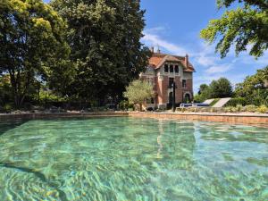 a large pool of water in front of a house at Chateau Mezger in Albefeuille-Lagarde