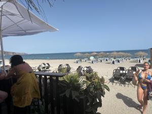 un grupo de personas sentadas en la playa en 3 dormitorios aguadulce pool, en Aguadulce