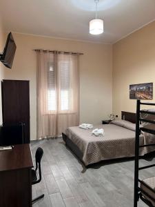 a bedroom with a bed and a desk and a television at B&B Metropolitan RC in Reggio di Calabria +43 photos