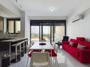 a living room with a red couch and a table at Modern Apart only Steps from Beach in Larnaka