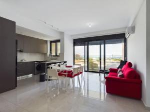 a living room with a red couch and a table at Modern Apart only Steps from Beach in Larnaka