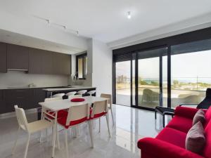 a living room with a red couch and a table at Modern Apart only Steps from Beach in Larnaka +15 photos