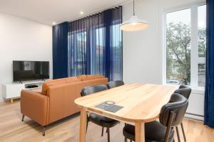 a dining room with a table and a couch at Les Lofts de Vitré - Par Les Lofts Vieux-Québec in Quebec City