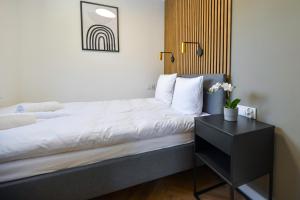 a bedroom with a bed and a black nightstand at Magic Apartments - Aroma Zator in Zator
