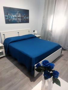 a bedroom with a bed with blue sheets and blue roses at B&B Metropolitan RC in Reggio di Calabria