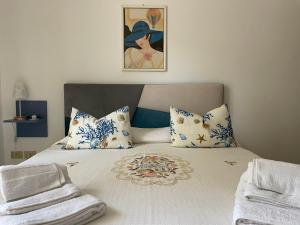 a bed with blue and white pillows and a painting at Casa Vacanze Villa Lena in Santa Flavia