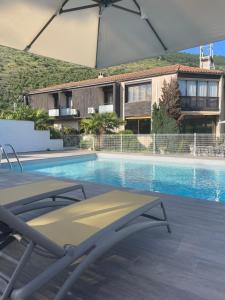 una piscina con una sedia e un ombrellone di Hôtel Pyrène a Foix