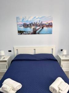 a bedroom with a blue bed with two white towels at B&B Metropolitan RC in Reggio di Calabria