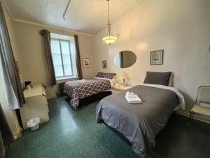 a bedroom with two beds and a chair and a mirror at Auberge du Couvent in Saint-Casimir +44 photos