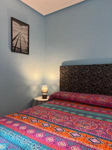 a bedroom with a bed with a colorful bedspread at Piso Los Jardines in Peñaranda de Bracamonte