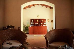 a living room with two wicker chairs and an entry way at AgriturismoBugilfezza di TGESD in Modica