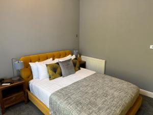 a bedroom with a large bed with a yellow headboard at The Red Lion Hotel in Cromer
