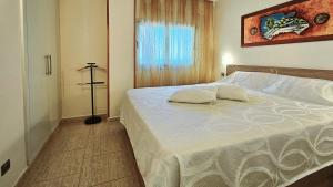 a bedroom with a white bed with a window at Perla del Paraiso in Playa Paraiso +9 photos