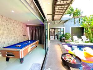 a pool table in a living room next to a pool at Heartbeat Fall in Love in Sattahip