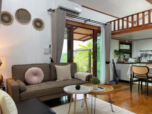 a living room with a couch and a table at Anna River Home A2 in Ban Khlong Si